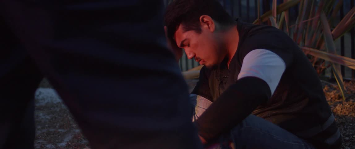 Distraught looking man sits with hand on top of his head
