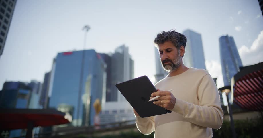 The man is writing on his tablet with a stylus