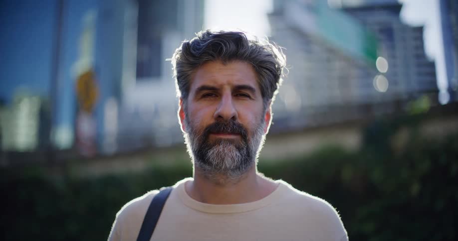 Man in an urban area positioned with buildings in the background