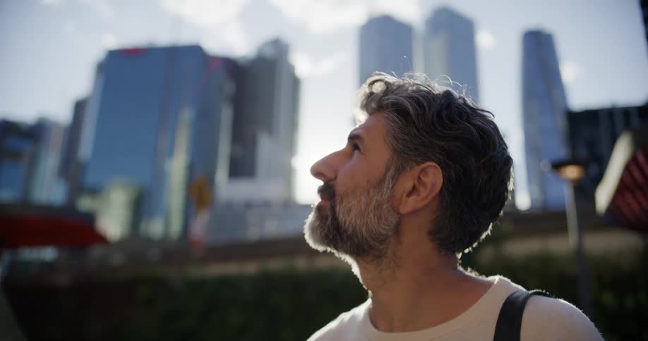 Man observing tall buildings in an urban area