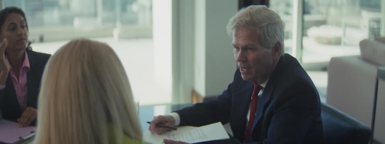 People sitting at a table having an office meeting as a man speaks
