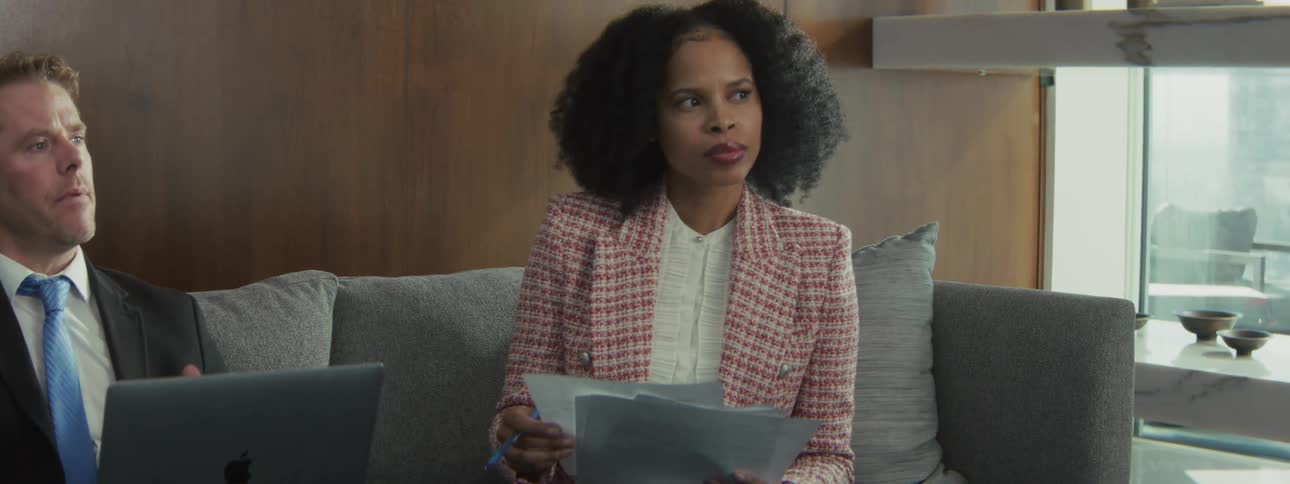Woman holding documents while attending a meeting on a corporate sofa