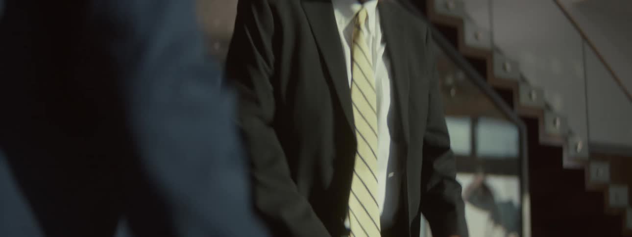 Two employees stand up from an office table and leave