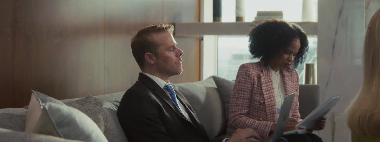 A group of people sitting in an office talking