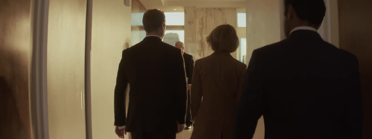 Office workers of different ages walking around and greeting in an office indoors during day time