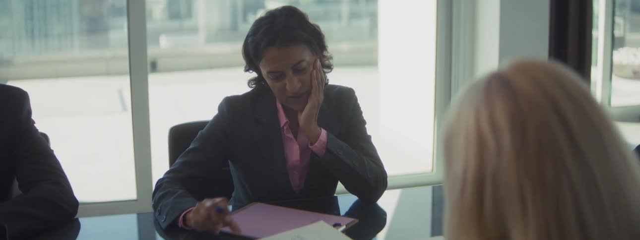 Woman reviewing documents with a clipboard during a meeting