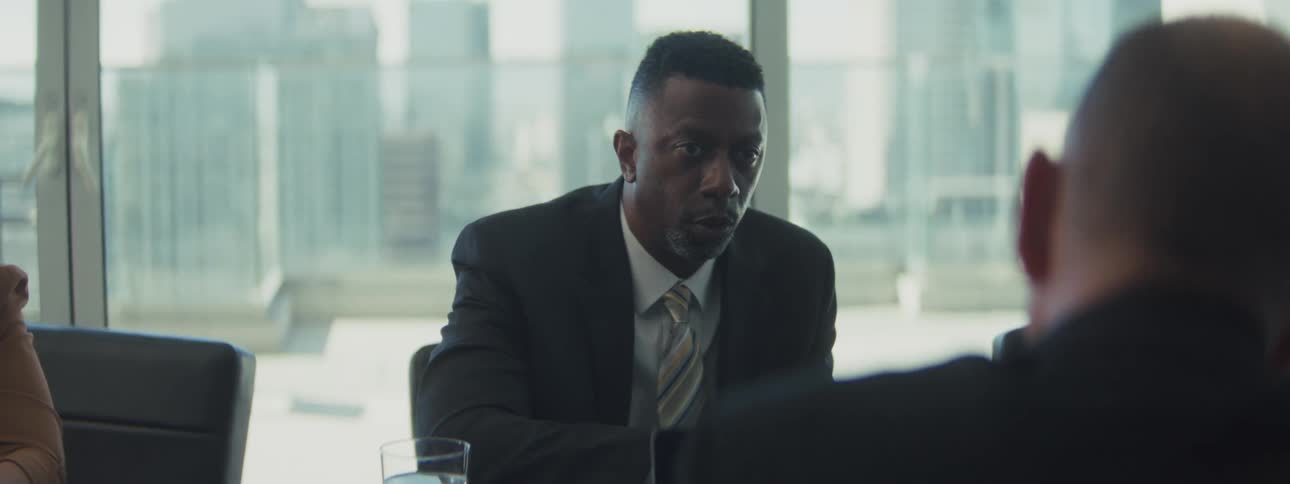 Small group of people from different ethnicities and ages sitting down and talking on a business meeting indoors during day time
