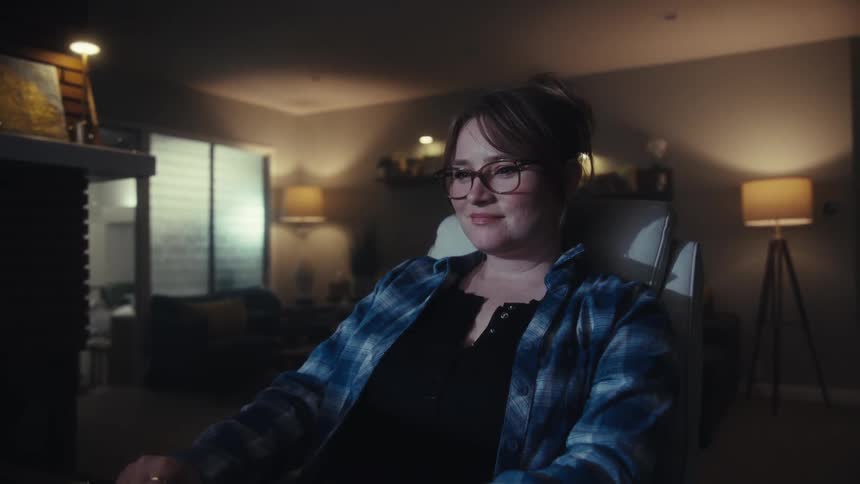 The woman types on her keyboard and smiles