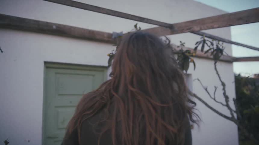 A man and woman engage in a heated argument outdoors as she tries to walk away and he follows her