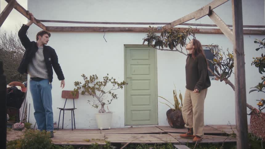 Man and woman talking on a house veranda