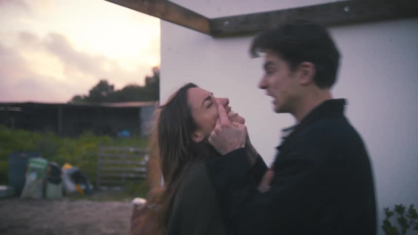 Couple arguing in an outdoor area near a white structure