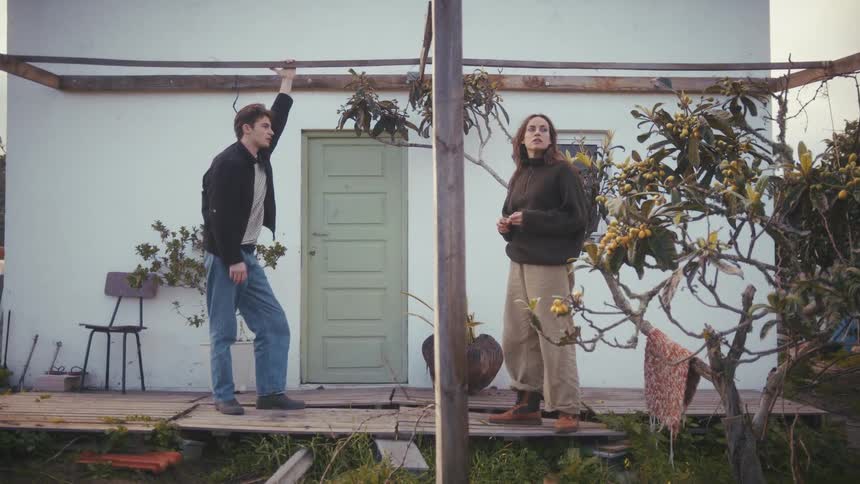 The man and woman talk by the door of the home