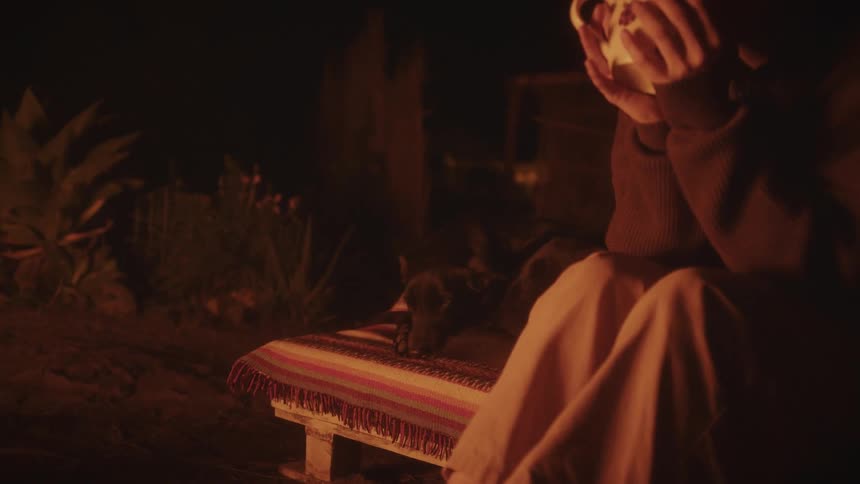 A person sitting outdoors next to a dog