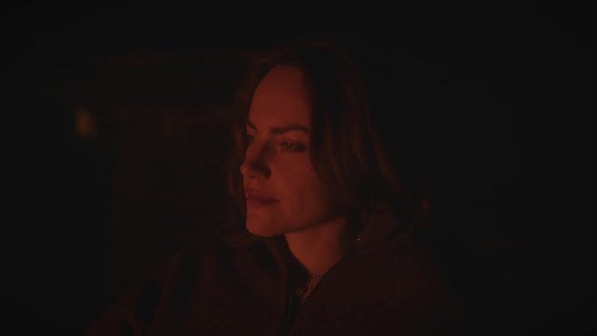 Woman lit by warm light in a dark environment