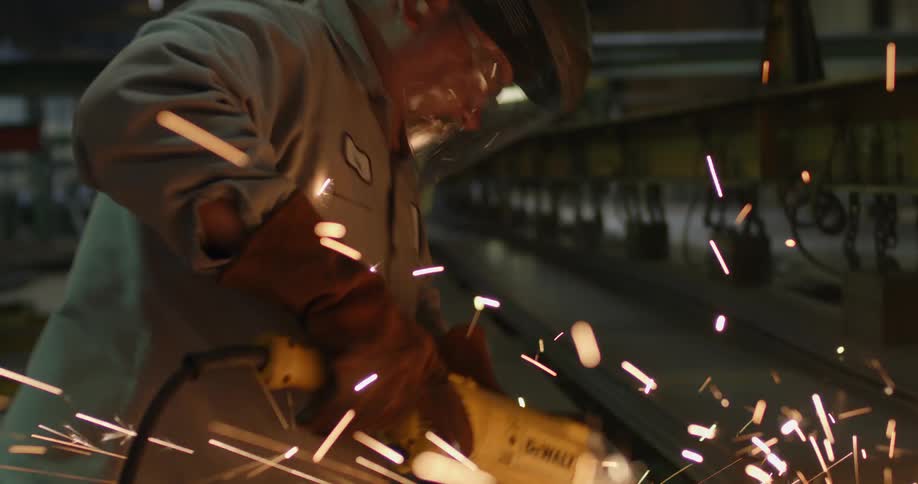 Man sands a piece of sparking metal