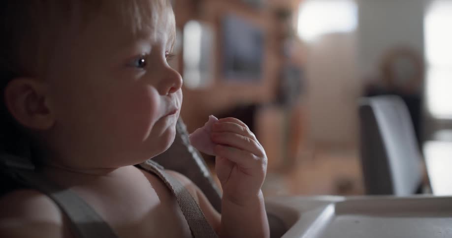The baby is eating and smiling