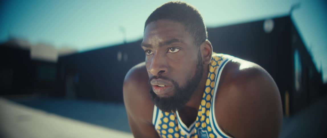 Close up of a male black athlete standing at an outdoor playing court during daytime