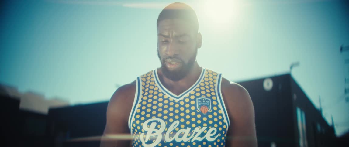 The basketball player is holding the ball in the lot
