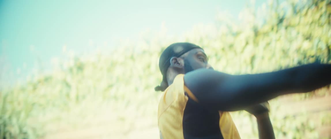 The video shows an athlete wearing a yellow jersey with the word blaze and the number 17 catching a football overhead and then preparing to throw or run with it the setting appears to be outdoors on a bright sunny day with lush green foliage and t
