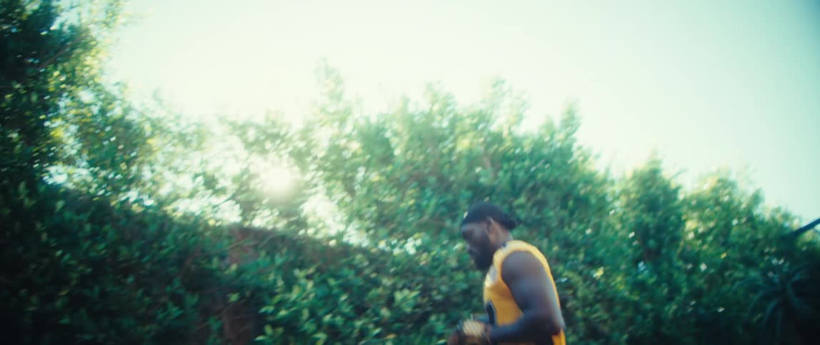 A young black male athlete playing football outdoors during daytime