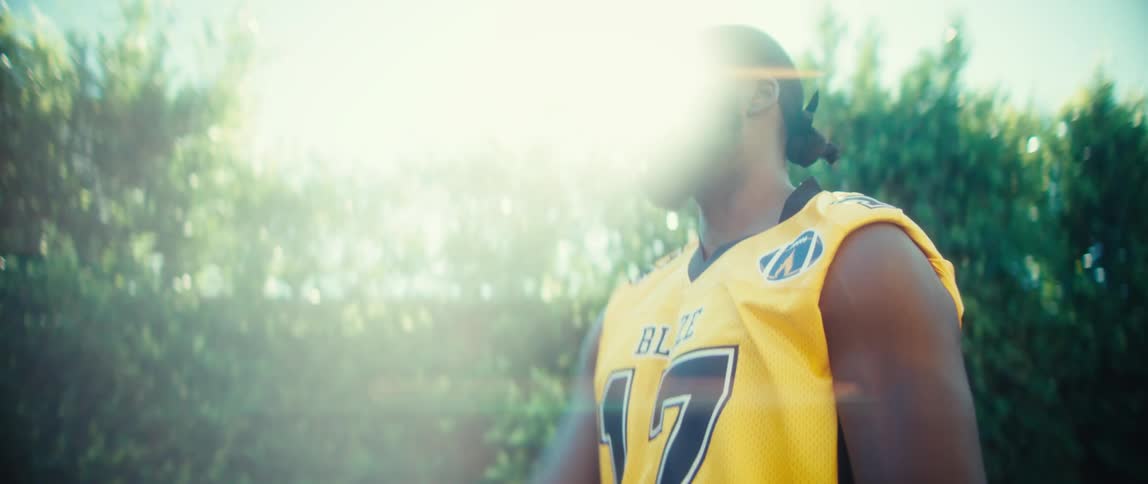 Man wearing a sports jersey looking upward on an outdoor court