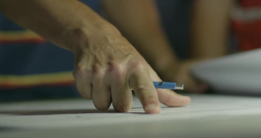 A person is writing on some blueprints