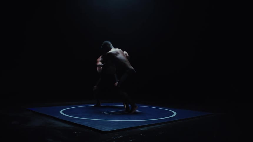 Two men are wrestling and throwing each other around