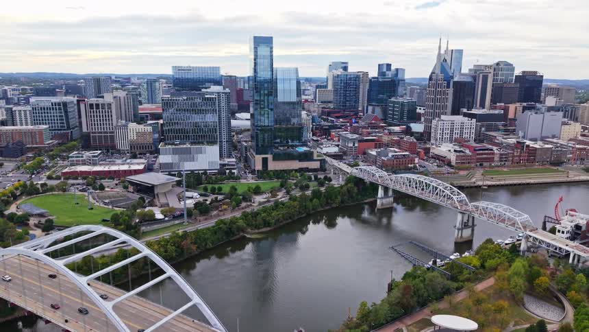 Waterfront of a metropolitan area with suspended bridges and traffic next to high rises and skyscrapers outdoors during day time