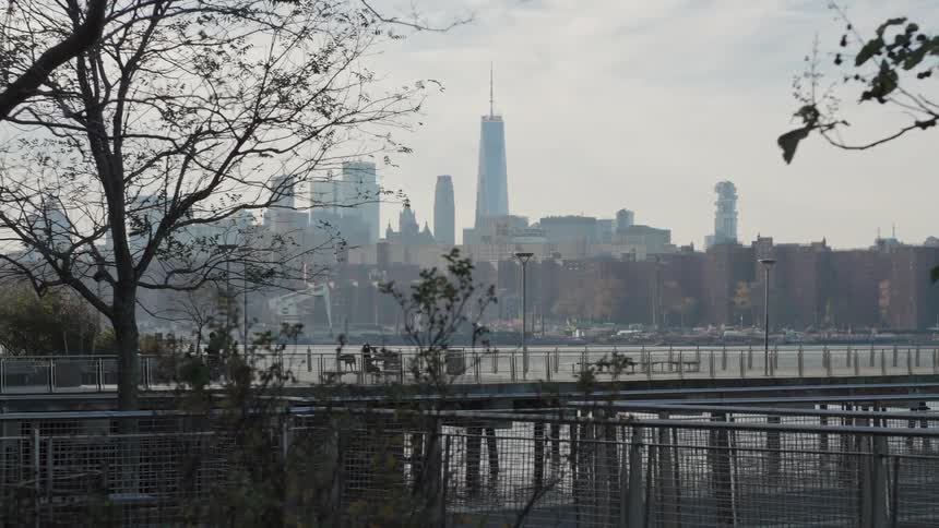 Pedestrian walks near the waterfront across the water from downtown on a foggy day