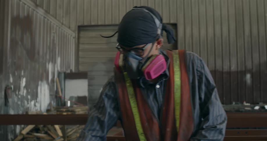 A man works in a shop with a hose