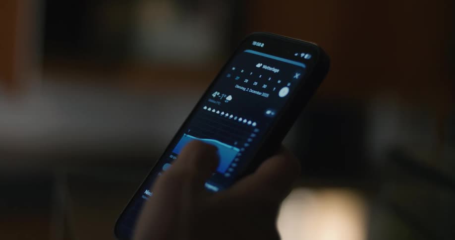 Hand interacting with a weather app screen on a smartphone displaying the forecast for new york