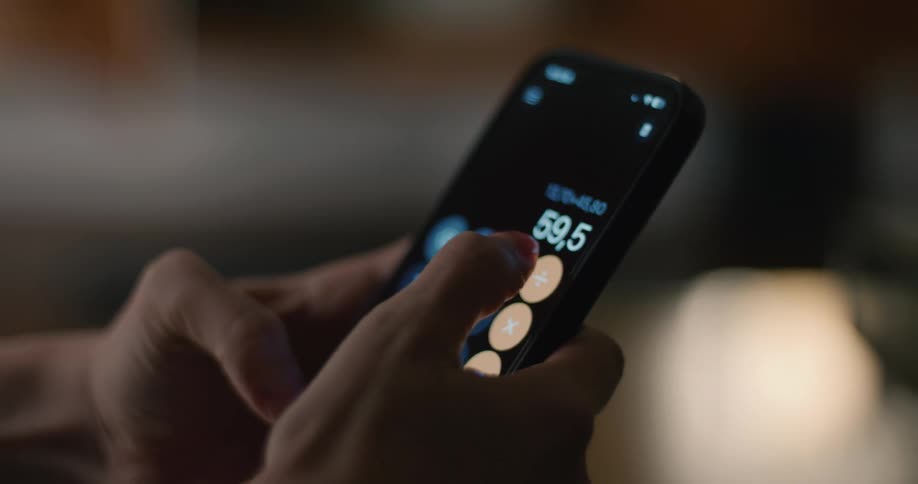 Woman uses the calculator app on her smartphone