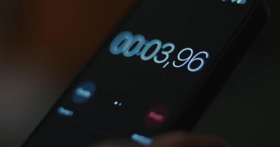 A person holds a mobile device while looking at a countdown timer