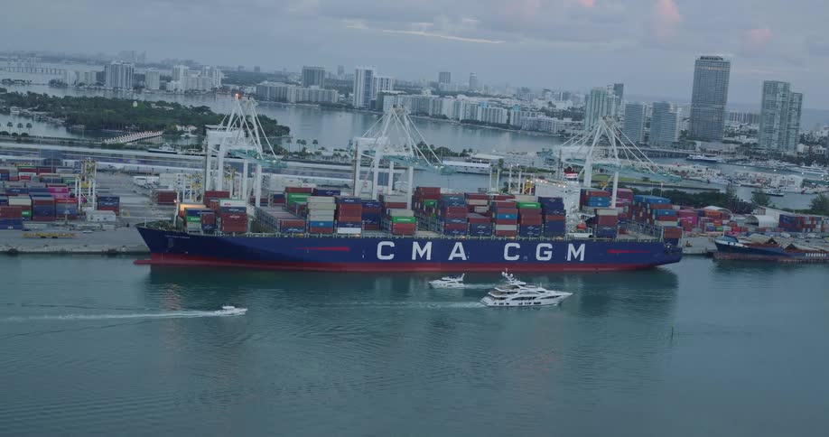 A large cargo ship is loaded with large shipping container at a shipyard