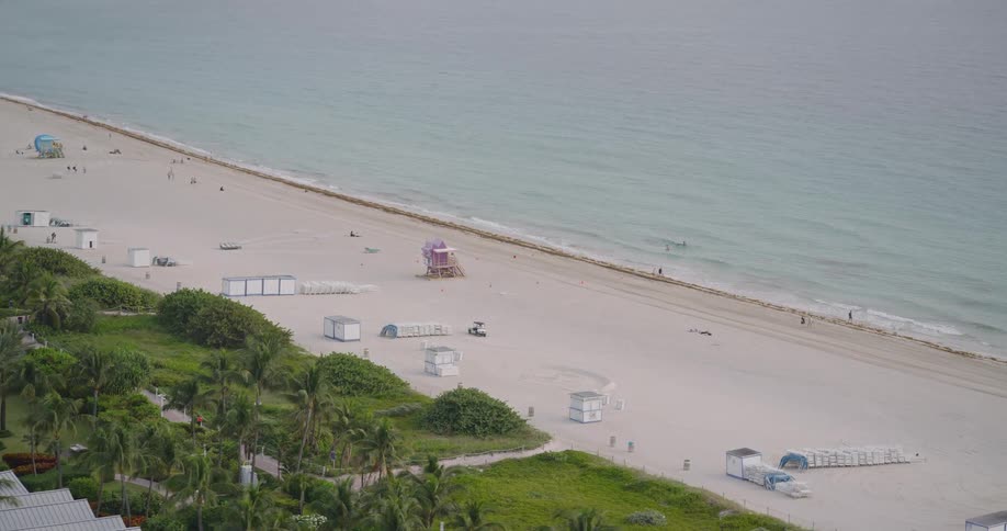People enjoy the beach and the nearby park on a summer day
