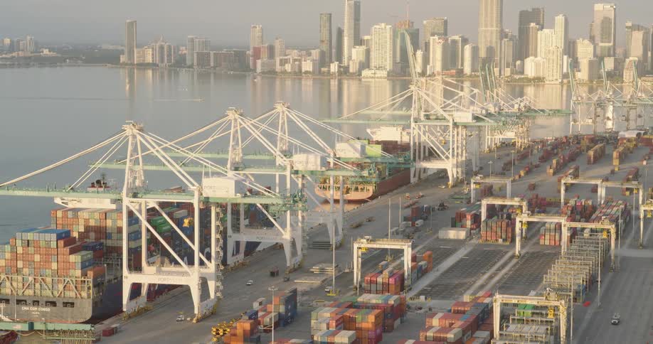 Port terminal with cranes and containers with an urban skyline in the background
