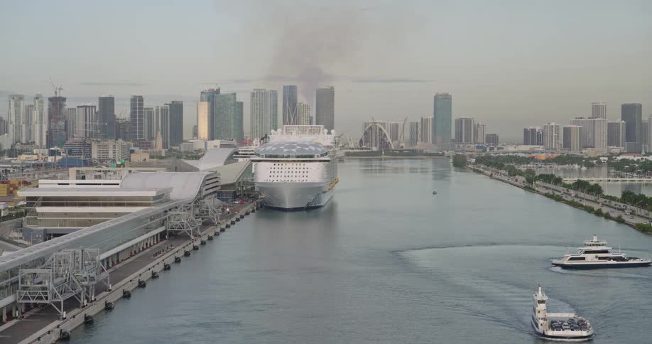 Aerial of a cruise ship docked in the harbor of a large port city