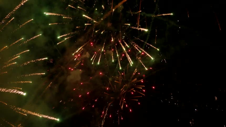 The video shows a display of fireworks exploding against a dark night skyvarious fireworks create bursts of light in colors like gold green and red