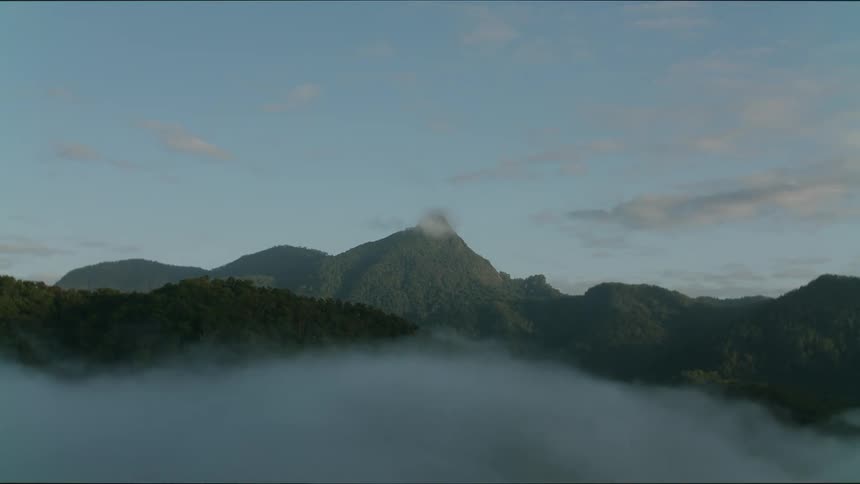 Mountains surrounded by valleys and fog outdoors during dusk or dawn