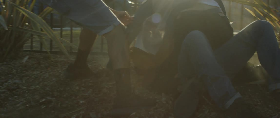 Men fighting on the ground as another tries to break it up