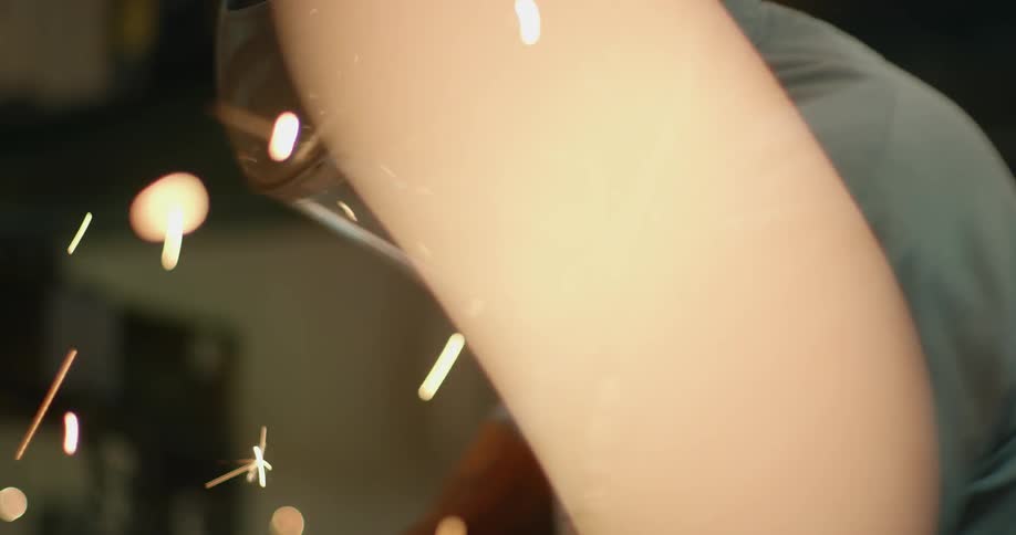 Man works while sparks fly around him