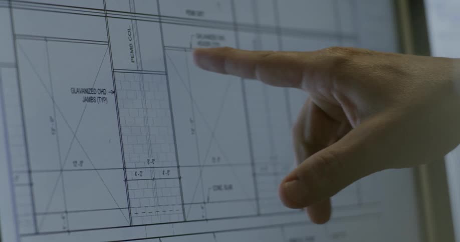 A person points at a blueprint