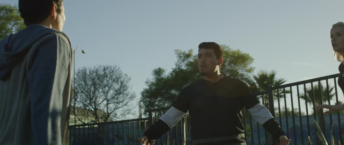 Two men argue outside on a sunny day