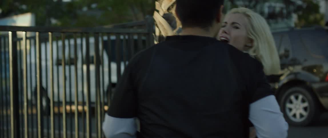 A man grabs an angry woman and turns her to face him