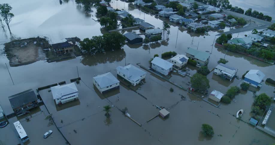 A devastating aerial view reveals an entire neighborhood submerged by murky floodwaters with homes and streets lost beneath the rising tide