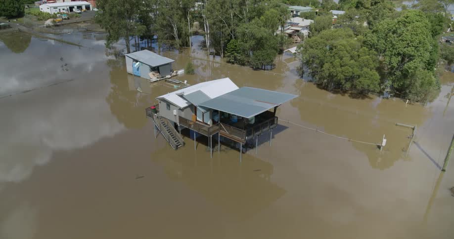Aerial view of a house built on stilts in a flooded neighborhood