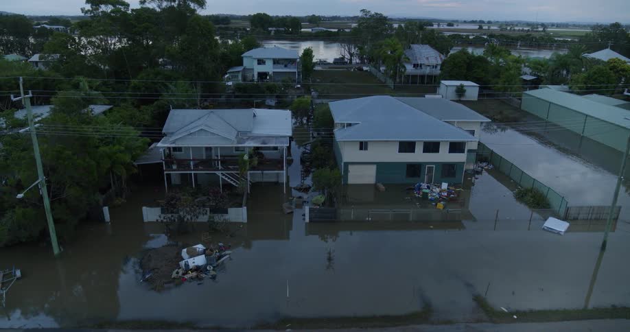 A residential area engulfed by a flood of brown water seen from above
