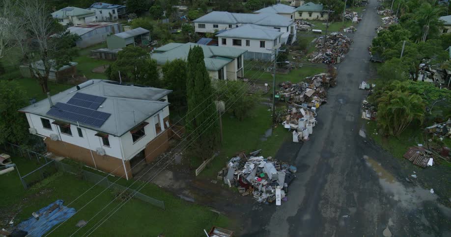 Aerial view of a suburban street covered in debris and ruined belongings after a flood