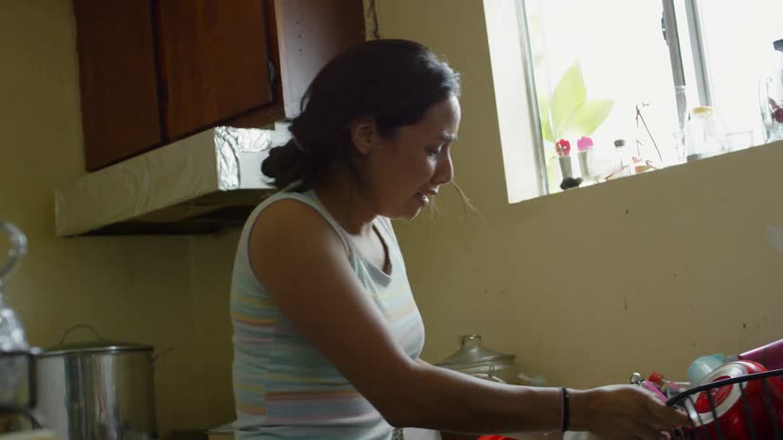 A man and a woman getting into a physical fight in a kitchen