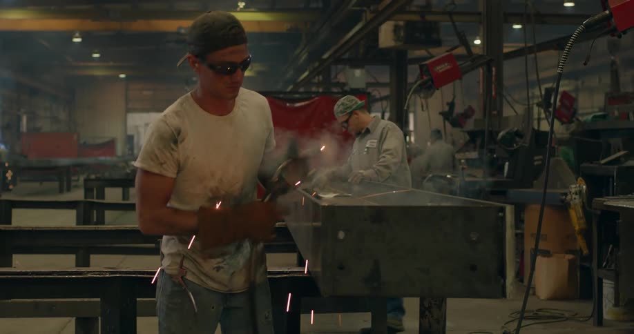 An industrial worker is working on a metal beam